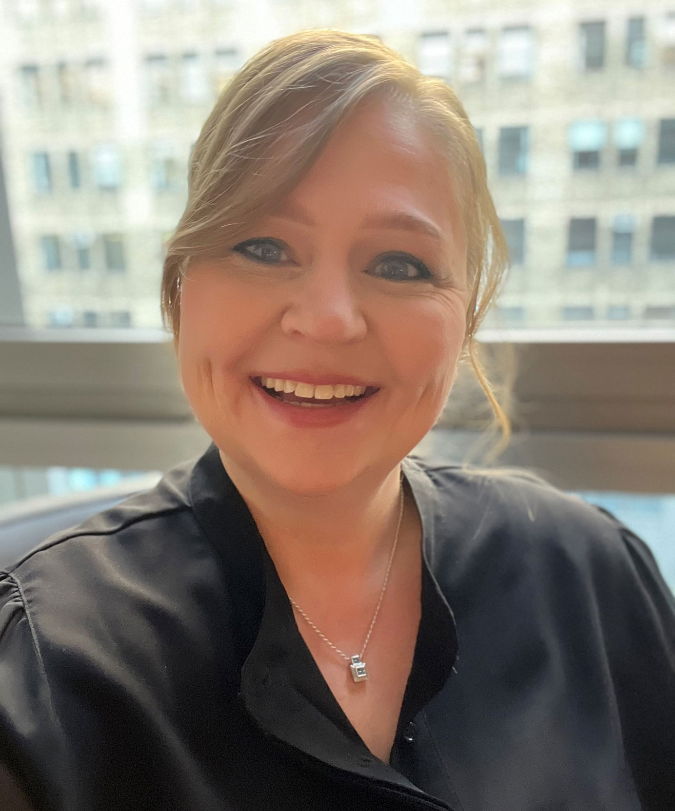 Tina Lambert smiling wearing a black blouse